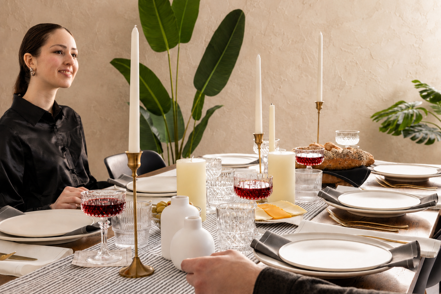 Warm-toned tablescape with layered napkins, candles, and ceramic plates